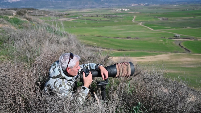 wildlife photographer on safari with telephoto
