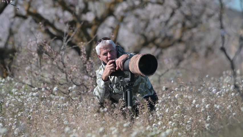 wildlife photographer on safari with telephoto