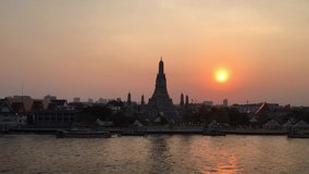 Timelapse of illuminated Temple of Dawn or Wat Arun and its reflection in Chao Phraya River at sunset and night. Bangkok, Thailand. Full HD time lapse video clip