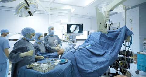 Team of professional surgeons and nurses operating a knee