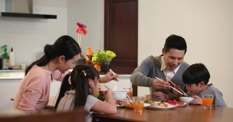 Happy family enjoy breakfast together. Cheerful young asian parents and cute small kids enjoy breakfast together on dining table at home. wonderful moment family concept 4k footage.