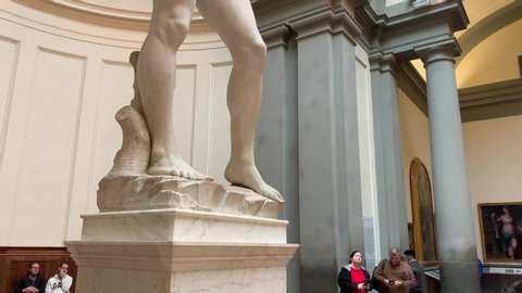 Florence, Italy -  January 25, 2020: People inside of famous Florence Accademia art museum gallery looking at view of David statue of Michelangelo