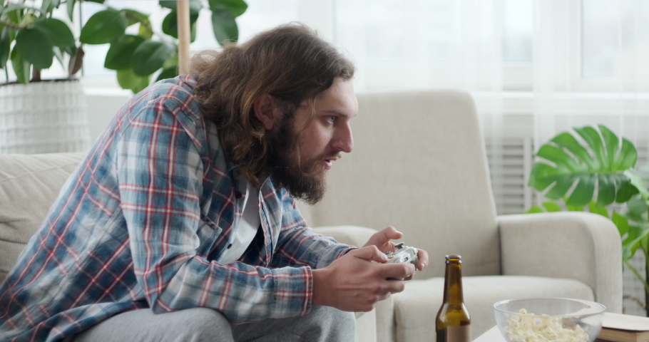 Man celebrating victory while playing video game at home | Shutterstock HD Video #1048073770
