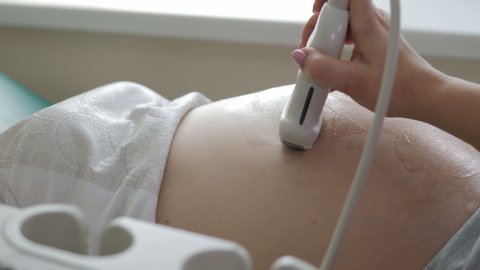 Close-up view of the doctor doing an nultrasound to a pregnant woman