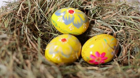 Colored Easter eggs. Hand picks up some eggs from a chicken of straw. Colored Easter eggs. Easter concept