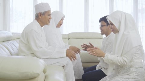 Young muslim couple apologizing to their parents during Eid Mubarak at home. Shot in 4k resolution