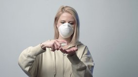 Blonde woman in protective mask with disinfection gel