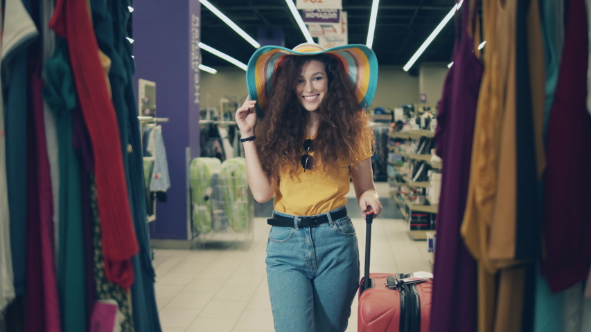 Young lady is smiling and walking along the shop