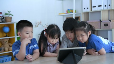 Educational concepts. Children are interested in learning with a tablet in the classroom, With a bright smiley face.