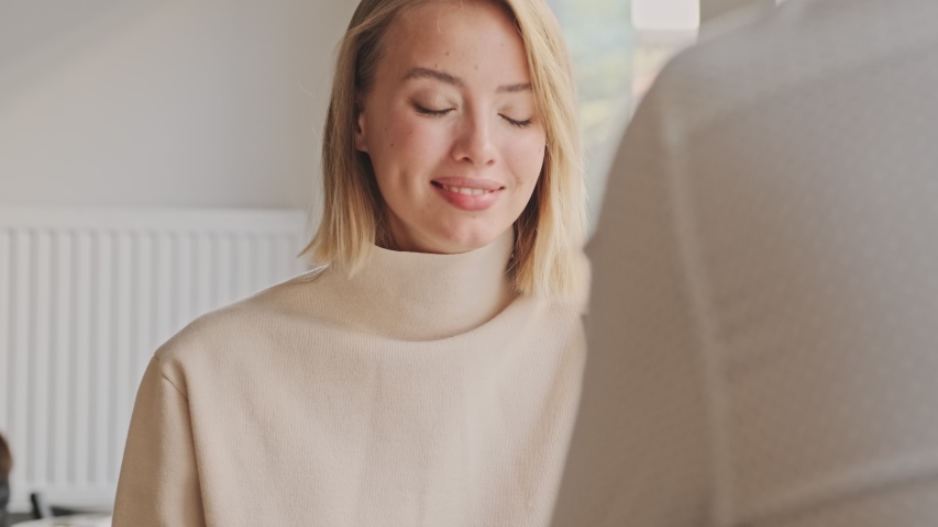 A lovely young couple wearing casual clothes is sitting at the white cafe while having a date