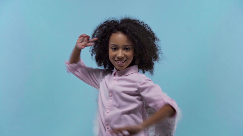 african american kid with angel wings dancing isolated on blue
