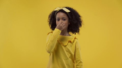 curly african american kid dancing isolated on yellow