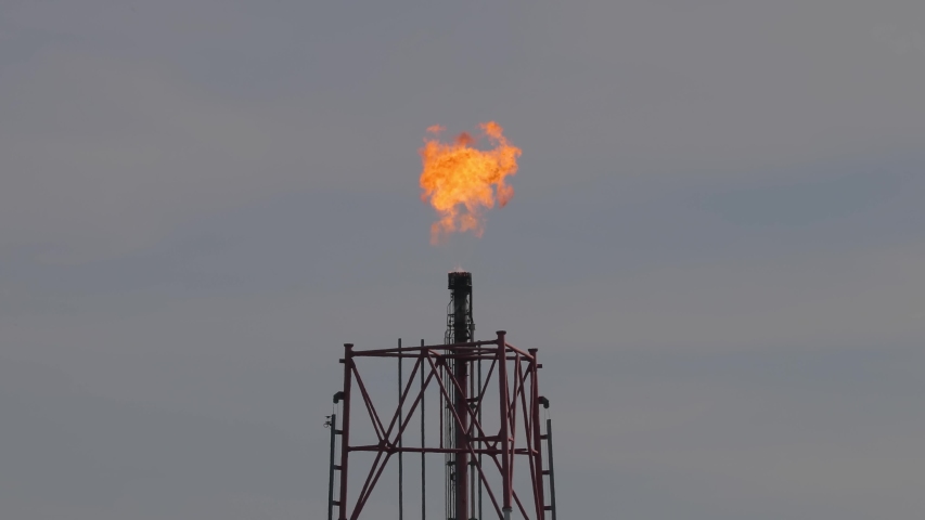 Torch flame at an oil refinery through heavy heat haze vibration in the air