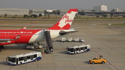 DON-MUEANG, BANGKOK - MAR, 2020 : Don-mueang International Airport view, Airplane parking at parking bay. Ground Handling services, passenger bus or apron bus on duty, operate in Airport 