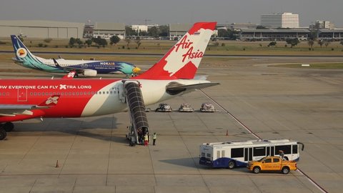 DON-MUEANG, BANGKOK - MAR, 2020 : Don-mueang International Airport view, Airplane parking at parking bay. Ground Handling services, passenger bus or apron bus on duty, operate in Airport 