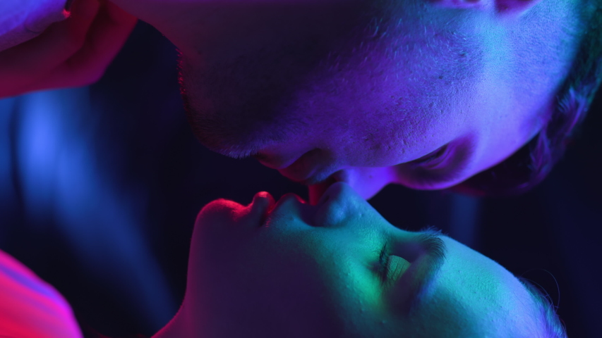 Two Lovers Kissing in Colourful UV Light of Room or Nightclub. Intimacy of Couple in Multi-Colour or Ultra-Violet Filter Closeup. Modern Love of Young Pair in Rainbow of Neon. Vertical Video Format