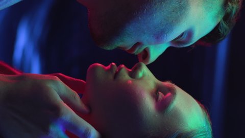 Lovers Kissing in Colourful UV Light of Night Club or Urban City. Intimacy of Couple in Multi-Colour Illumination or Ultra-Violet Filter Closeup. Love of Pair in Rainbow of Neon. Vertical Video Format