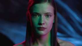 Portrait of Woman Looks at Camera in Colourful Filter. Multi-Colour of Neon Light at Dark Room. Young Lady in Ultra-Violet of Night Club Indoors. Fashion of Gorgeous Girl at Street of Futuristic City - Powered by Shutterstock - Get 15% off with code: PIKWIZARD15