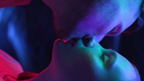 Two Lovers Kissing in Colourful UV Light of Club Room or Night City. Intimacy of Couple in Multi-Colour or Ultra-Violet Filter Close-Up. Modern Love of Pair in Rainbow of Neon. Vertical Video Format