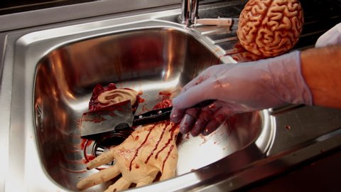 a mad doctor after tearing a man to pieces throws the knife on the bloody sink.