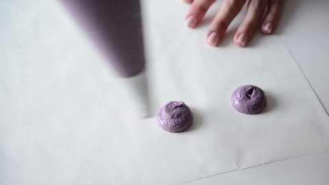 Cooking macaroon. Confectioner putting macaroon dough on the parchment for baking. Female making blueberry macaroons. Steps cooking baking macaroon and confectionery.