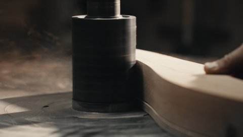 Close up video of Man's Hands working with Piece of Furniture and a Lathe in his Workshop. Carpenter scrape on the lathe a piece of Wood on his Workplace. Slow motion.