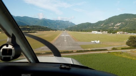 Landing of small aeroplane, cabin view live camera. Private aircraft lands on runway, airfield. Small airport in summer. Airplane is moving, propellers rotate and stop