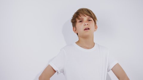 Happy teen boy wearing white tshirt and winks, have fun emotions at camera on white background.