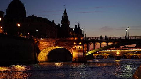Paris at night, Seine river bridge. Seen from tour sightseeing boat ship. Paris at night. Romantic honeymoon travel destination. Historic landmark.