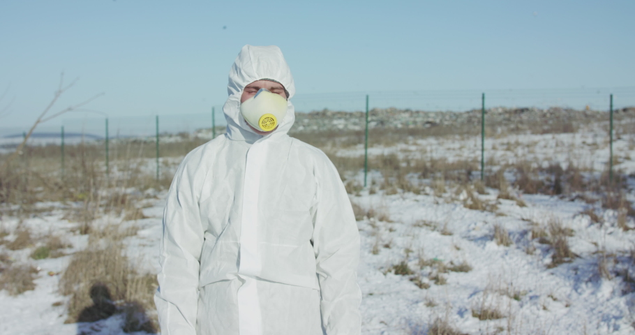Portrait of man in full cover suit shows stop with hands on abandoned nature in winter. Slowly in 4K