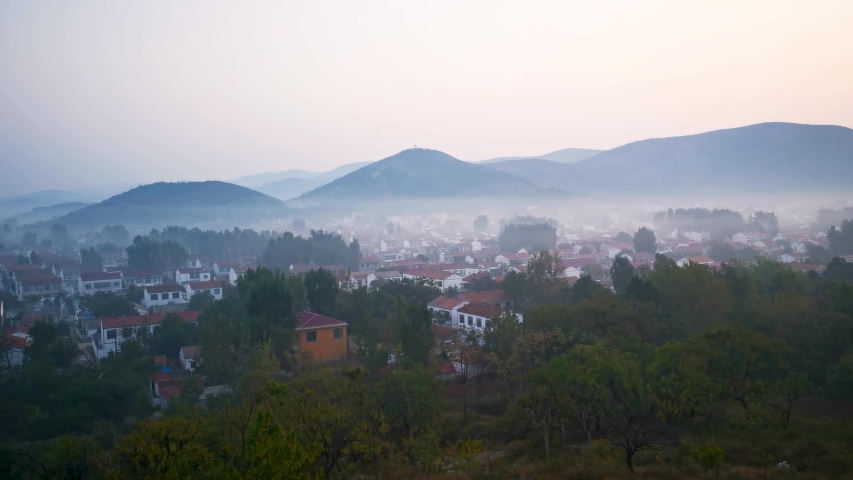 The village scenery surrounded by mountains in Huaibei City, Anhui Province, China, is foggy in the morning.