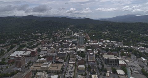 Asheville North Carolina Aerial v2 Flying through downtown to the northeast up hillside and over - July 2019