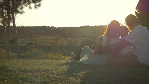 Beautiful family repationships concept that shows pure love, acceptance and expectations. A young family is expecting their second child and enjoying sunset in a park in Madrid Spain.