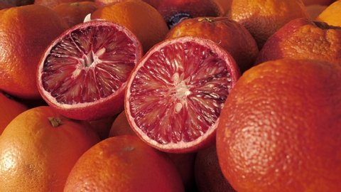 Close-up of a fresh blood oranges on fruit market. Boxes full of ripe oranges on farmers market. Organic fruit display in shop. Juicy crimson oranges at the greengrocer's stall. 