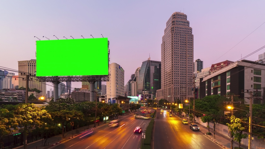 Time-lapse: Billboard with green screen and city traffic light background at day to night. 4K Resolution. Royalty-Free Stock Footage #1048196548