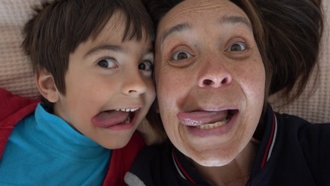 4K Selfie of Funny mother and son putting out their tongues
