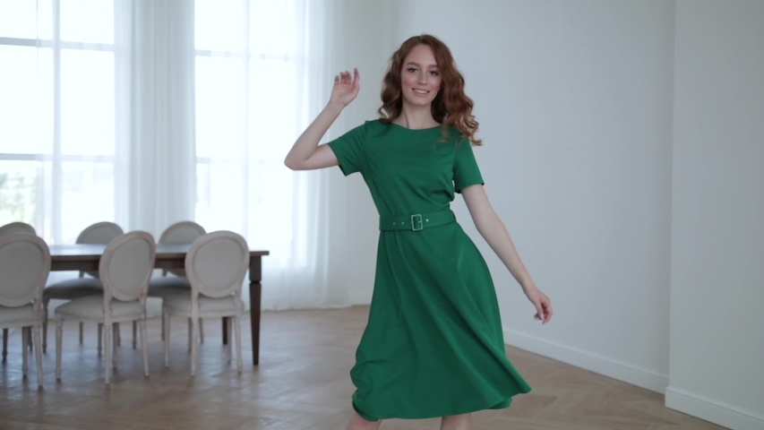 the girl with red hair was dressed in a beautiful dress, in a room with chairs