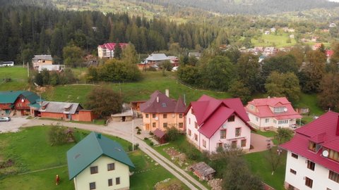 Aerial perspective shows modern houses with steeply pitched roofs in the remote village of Yaremche. Ukraine. in the Carpathian Mountains.