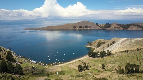 Aerial view over Isla del Sol, looking at the waters of Lake Titicaca - fly from island towards Lake