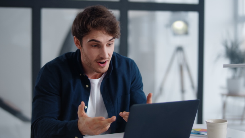 Smiling business man talking on video conference online in office. Handsome worker having video call on laptop computer indoor. Male professional explaining project with gestures at remote workplace | Shutterstock HD Video #1048224712