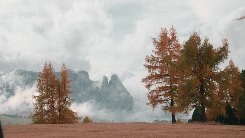 Caucasian man traveler hiking at high altitude in the misty, cloudy mountain peaks of the Dolomites in Italy.