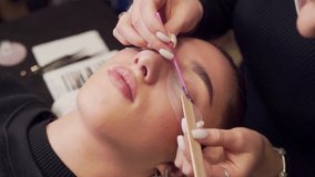 Closeup of eyelash extension master combs eyelashes