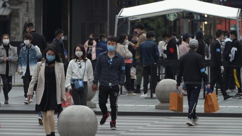 Chengdu, SichuanChina-March 4th 2020:Crowd walking in the street wear protective mask for protect Coronavirus, during  Covid 19 virus outbreak at Taikoo Li commercial town