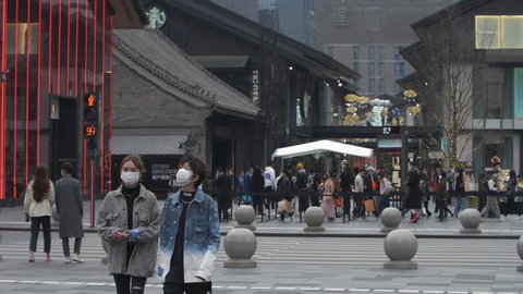 Chengdu, Sichuan/China-March 4th 2020:Crowd walking in the street wear protective mask for protect Coronavirus, during  Covid 19 virus outbreak at Taikoo Li commercial town