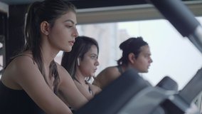 A movement shot of group of attractive youngsters training on stationary exercise bike. Male and female gym enthusiasts working out on stationary bicycles during cardio work out in a fitness studio. - Powered by Shutterstock - Get 15% off with code: PIKWIZARD15
