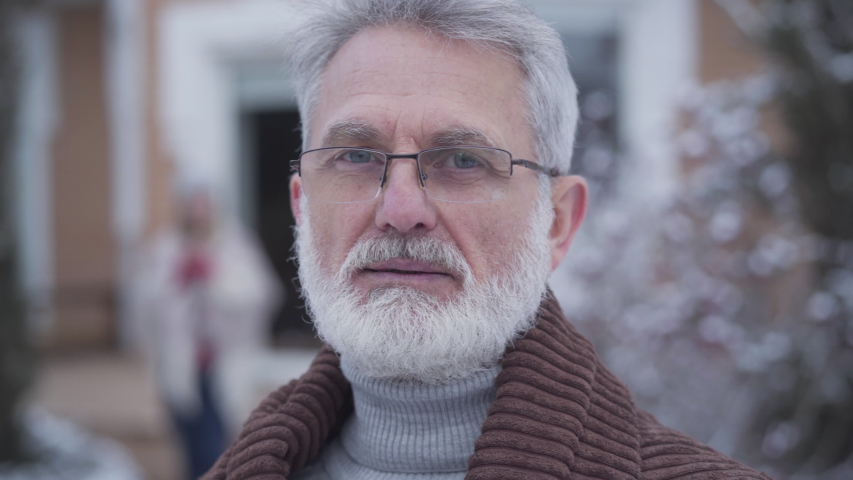 Close-up face of handsome graceful man in eyeglasses smiling at camera. Senior grey-haired Caucasian retiree posing outdoors on winter day. Lifestyle, leisure, relaxation. | Shutterstock HD Video #1048236451
