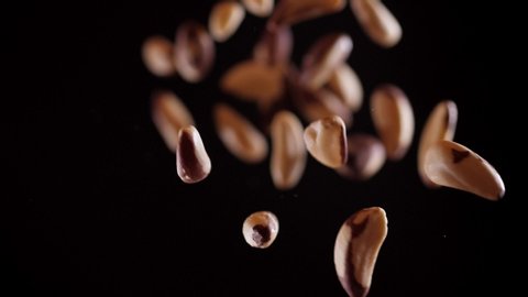 Brazil nut fly up and down on a black background. Healthy food. Vegetarianism. Protein from the brazilian nut. Cooking healthy food with brazil nut. Slow motion 360fps Stock-video