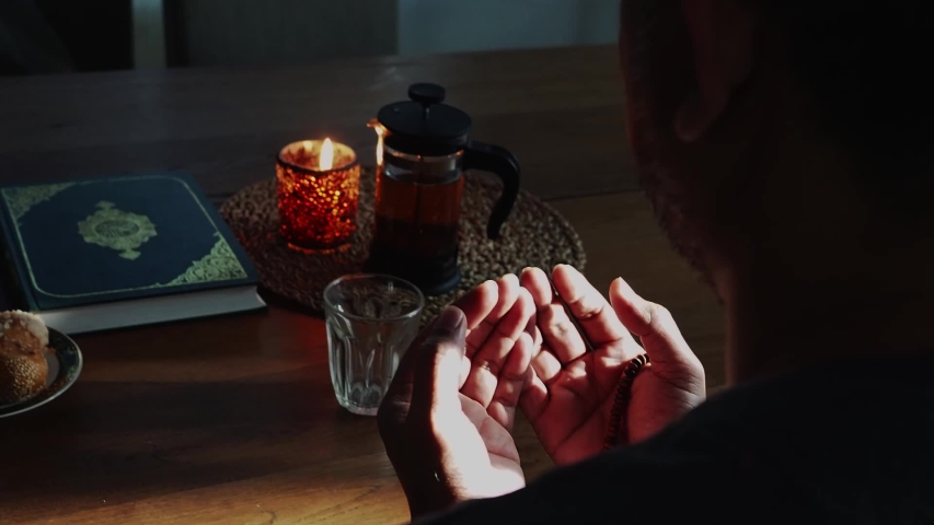 Fasting during Ramadan. Breaking the fast.Religious Muslim man praying to God.Muslim will breaking their fasting after sundown with date following the tradition of Muhammad with water or tea Royalty-Free Stock Footage #1048249399