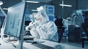Modern Factory: Team of Engineers and Scientists in Clean Sterile Coveralls Work on Desktop Computers, Use Microscope, Developing Solutions for High-Tech Medical Vaccine Research - Powered by Shutterstock - Get 15% off with code: PIKWIZARD15