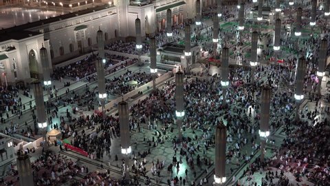 MEDINA, SAUDI ARABIA – DECEMBER 2019: Saudi Arabia religion and culture, crowds of pilgrims from across the world walk through holy Prophet's Mosque in Medina at night
